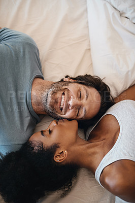 Buy stock photo Cropped shot of a happy young couple lying in bed together