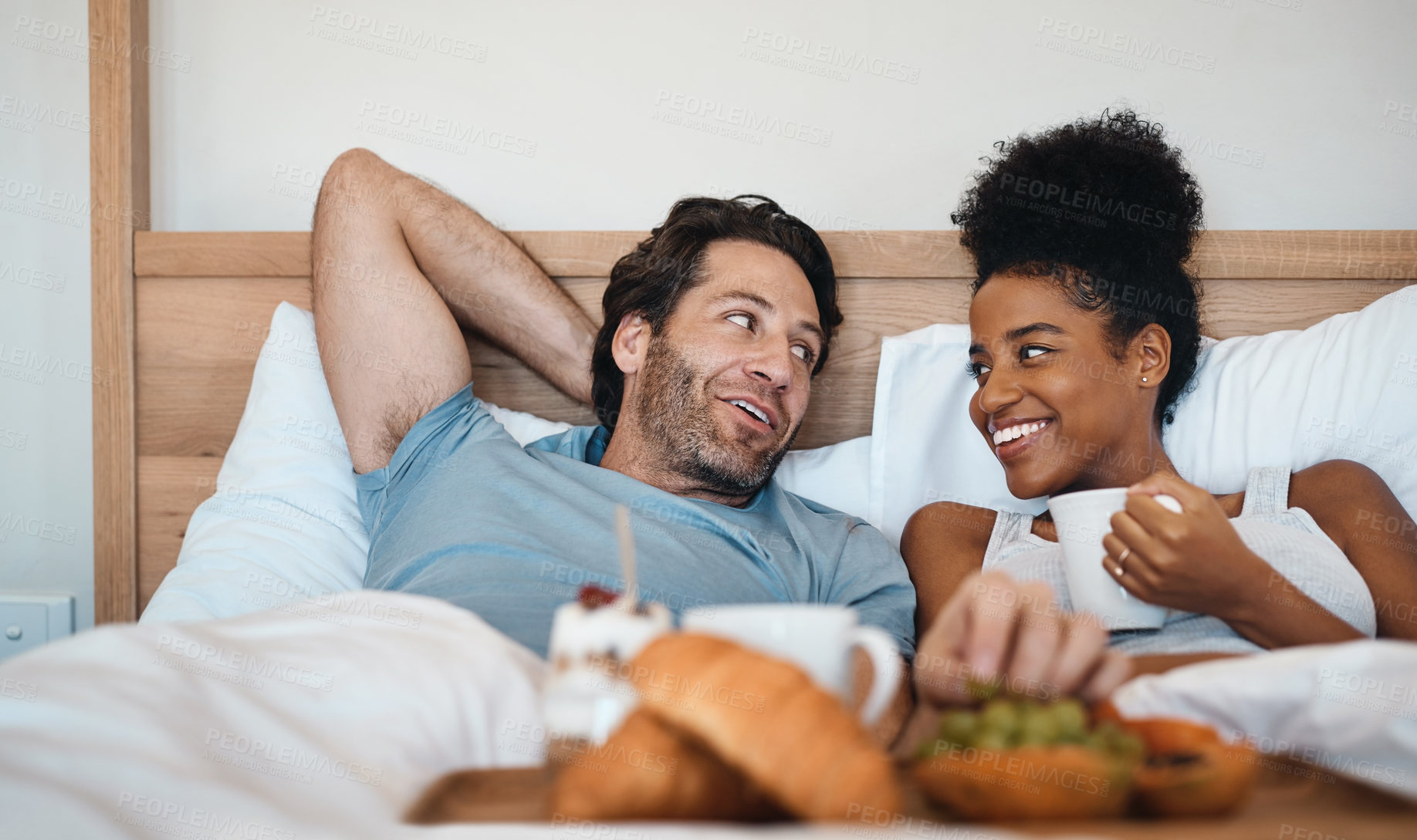 Buy stock photo Valentines surprise, birthday or interracial couple celebrate womens day breakfast in bed by a romantic, husband for his wife together. Sweet, in love and loving man serving his lady food and bonding