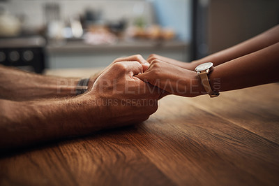 Buy stock photo Couple holding hands in support, grief and healing together on a wooden table at home. Closeup of a caring partner in sorrow due to cancer and expressing feelings of compassion in a house