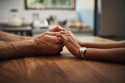 Buy stock photo Cropped shot of an unrecognizable couple holding hands while sitting together at a table