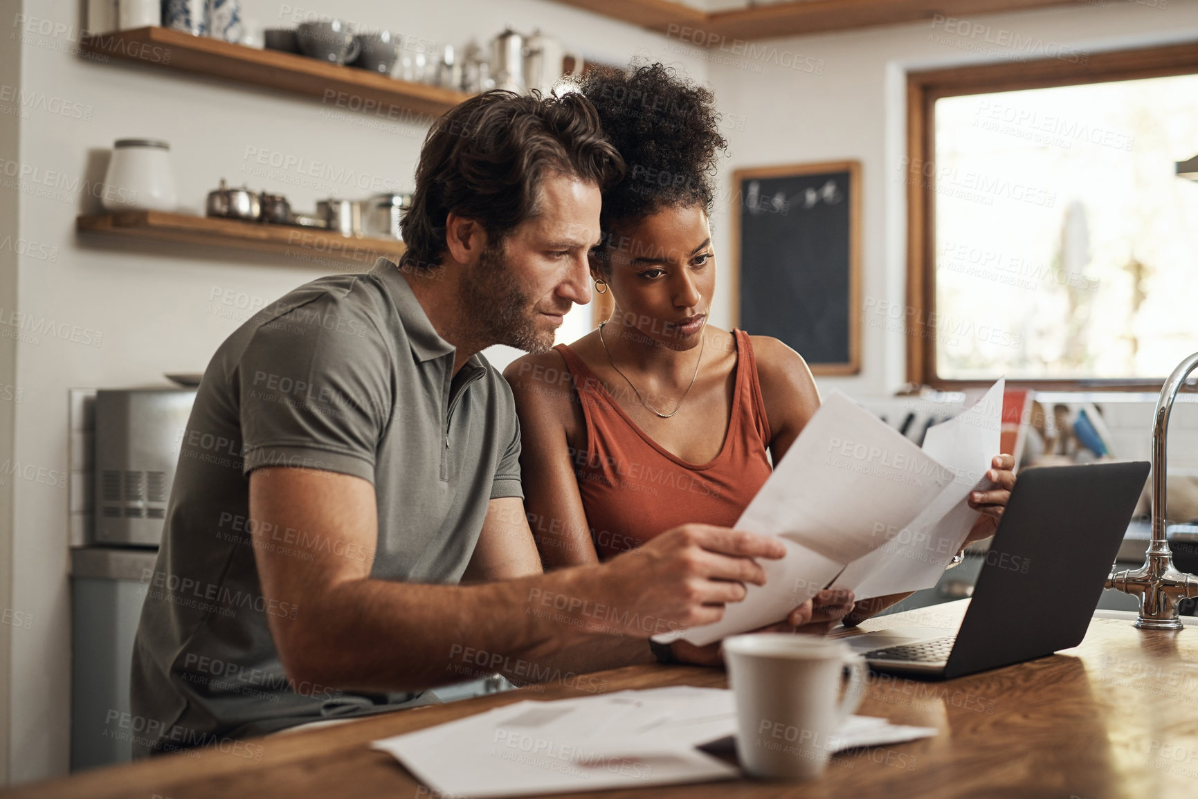 Buy stock photo Cropped shot of a couple using their laptop and going through paperwork at home