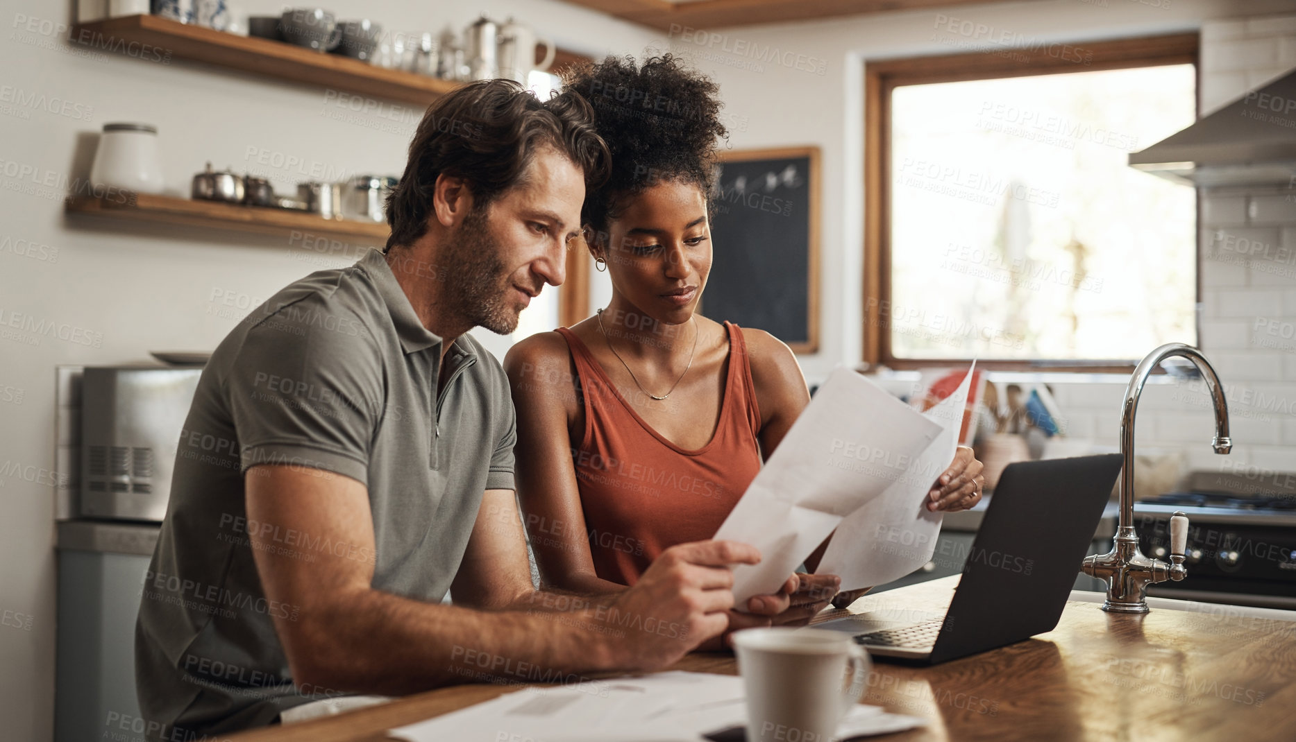 Buy stock photo Cropped shot of a couple using their laptop and going through paperwork at home