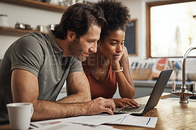 Buy stock photo Cropped shot of a couple using their laptop and going through paperwork at home