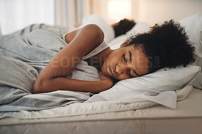 Buy stock photo Shot of a young woman looking upset while lying in bed with her partner