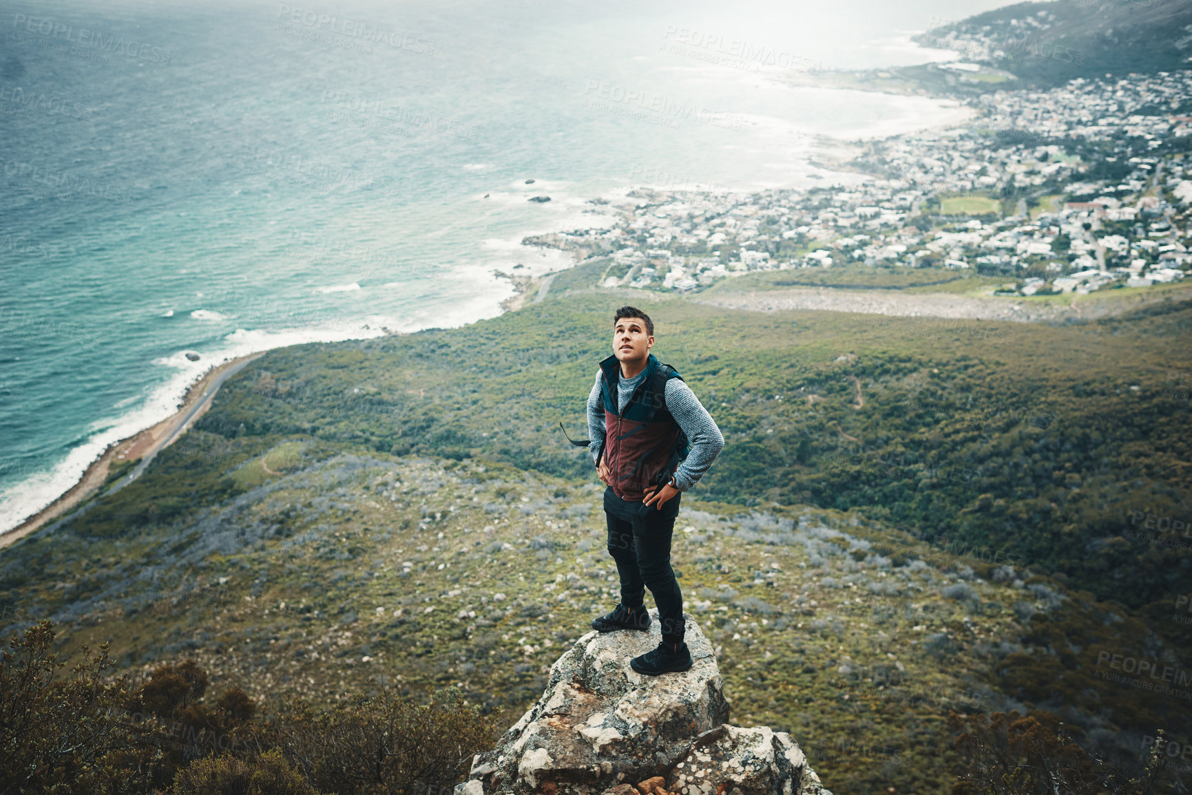 Buy stock photo Shot of a young man standing on a cliff while out on a hike