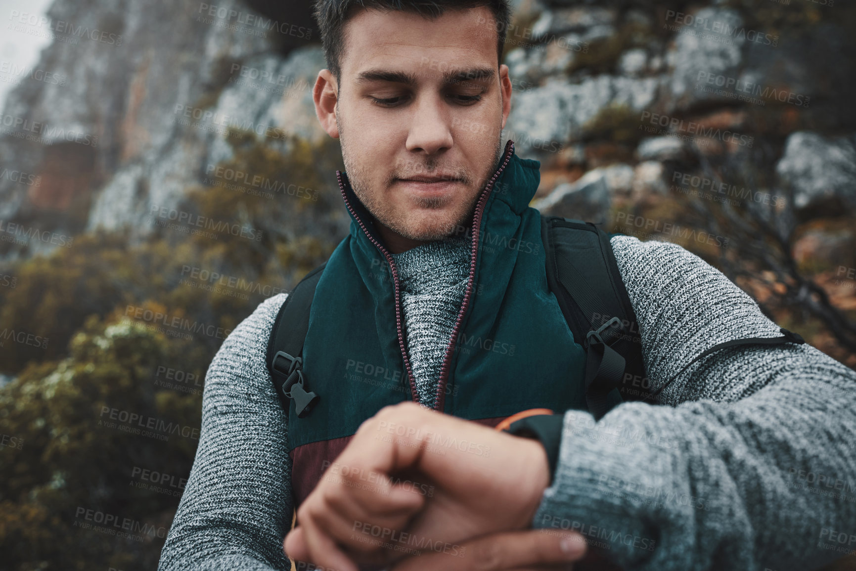 Buy stock photo Shot of a young man checking the time while out on a hike