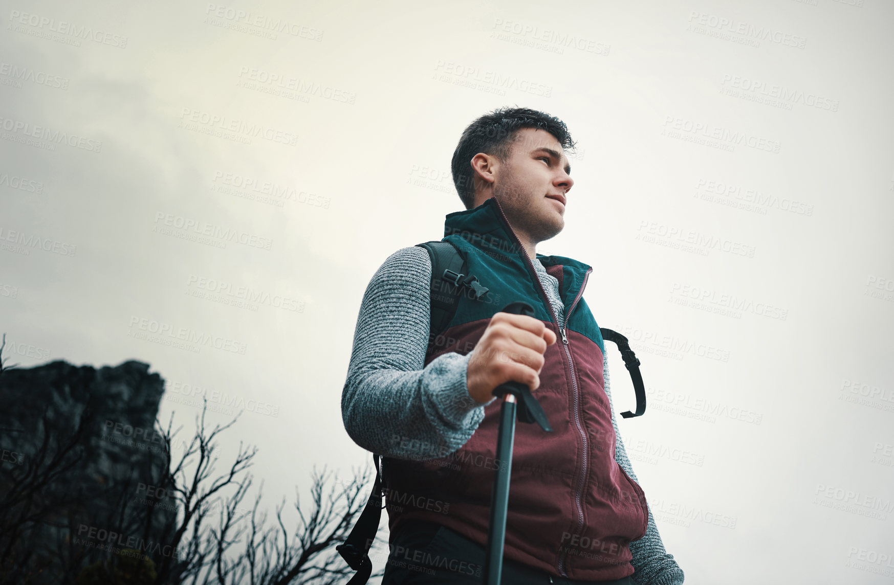 Buy stock photo Shot of a young man using a walking pole while out on a hike