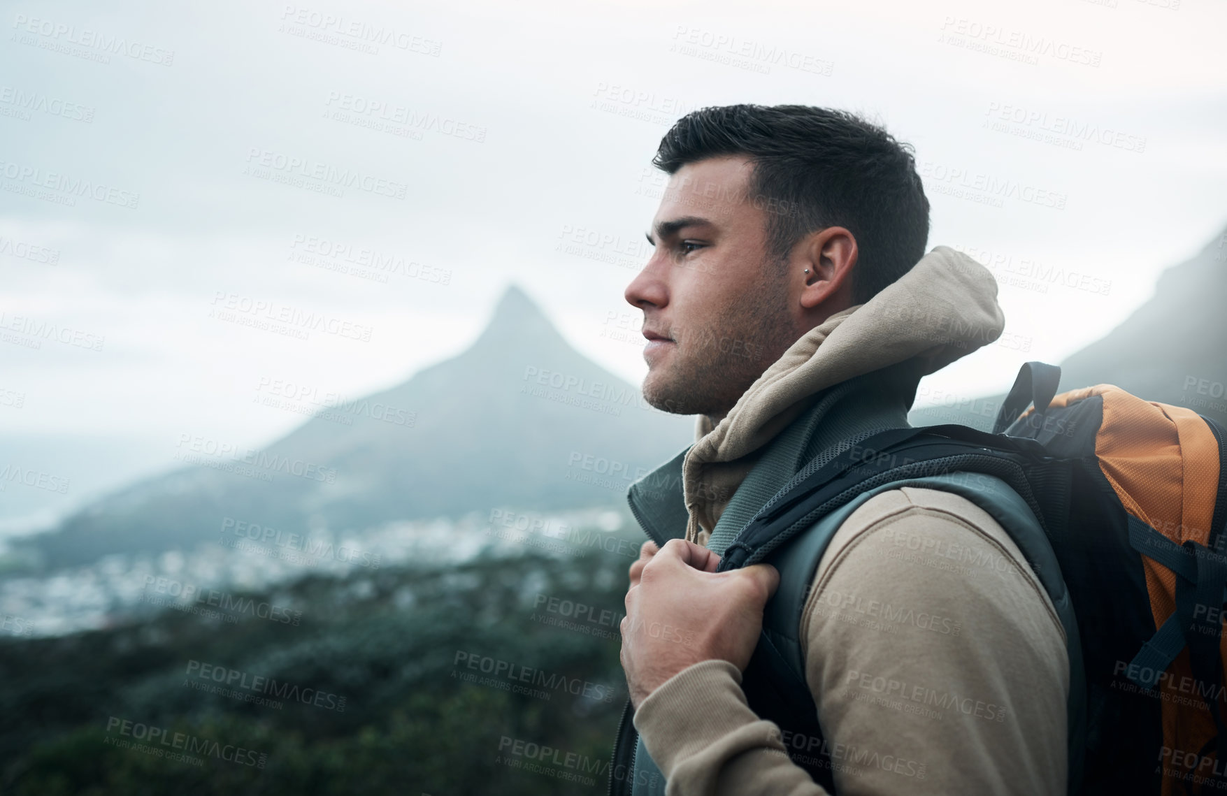 Buy stock photo Shot of a young man hiking through the mountains