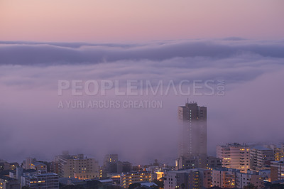 Buy stock photo Panoramic view of clouds covering buildings at sunset in the popular city of Cape Town, South Africa with copy space. A peaceful, misty sunrise over signal hill. Landscape of a modern town at night