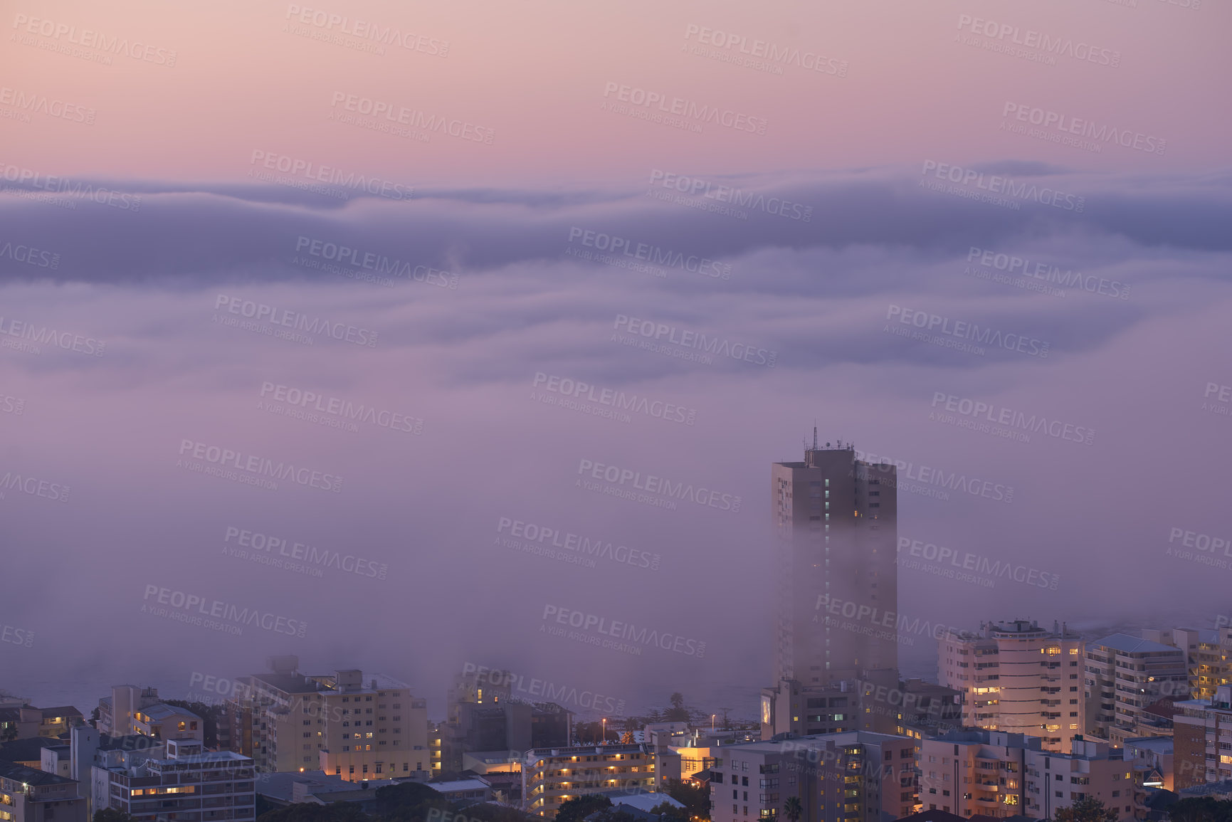 Buy stock photo Panoramic view of clouds covering buildings at sunset in the popular city of Cape Town, South Africa with copy space. A peaceful, misty sunrise over signal hill. Landscape of a modern town at night