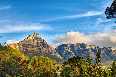 Buy stock photo Copy space with scenic landscape of cloudy sky covering the peak of Table Mountain in Cape Town on a sunny morning from below. Beautiful views of plants and trees around an iconic natural landmark