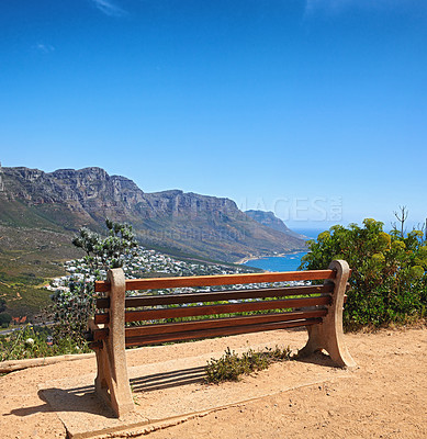 Buy stock photo Bench with a beautiful view of the mountain and sea against a clear blue sky background with copy space. Relaxing spot for a peaceful break to enjoy the scenic landscape after a hike up a cliff