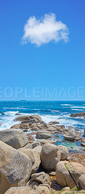 Buy stock photo Boulders at a beach shore with majestic ocean across the horizon. Copyspace at sea with blue sky background and rocky coast in Camps Bay, South Africa. Calm and scenic landscape for a summer holiday