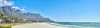 Buy stock photo Quiet and calm beach and ocean with sandy shore and palm trees. Scenic seascape of the Twelve Apostles mountain under a blue sky in Cape Town. A beautiful holiday destination for travel and tourism