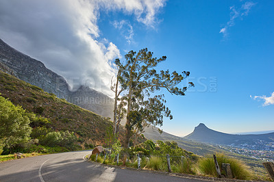 Buy stock photo Roadtrip through mountain view landscape on tar road or street with blue sky during summer in Cape Town, South Africa. Travel and leading to scenic, lush green hills for weekend exploring and driving