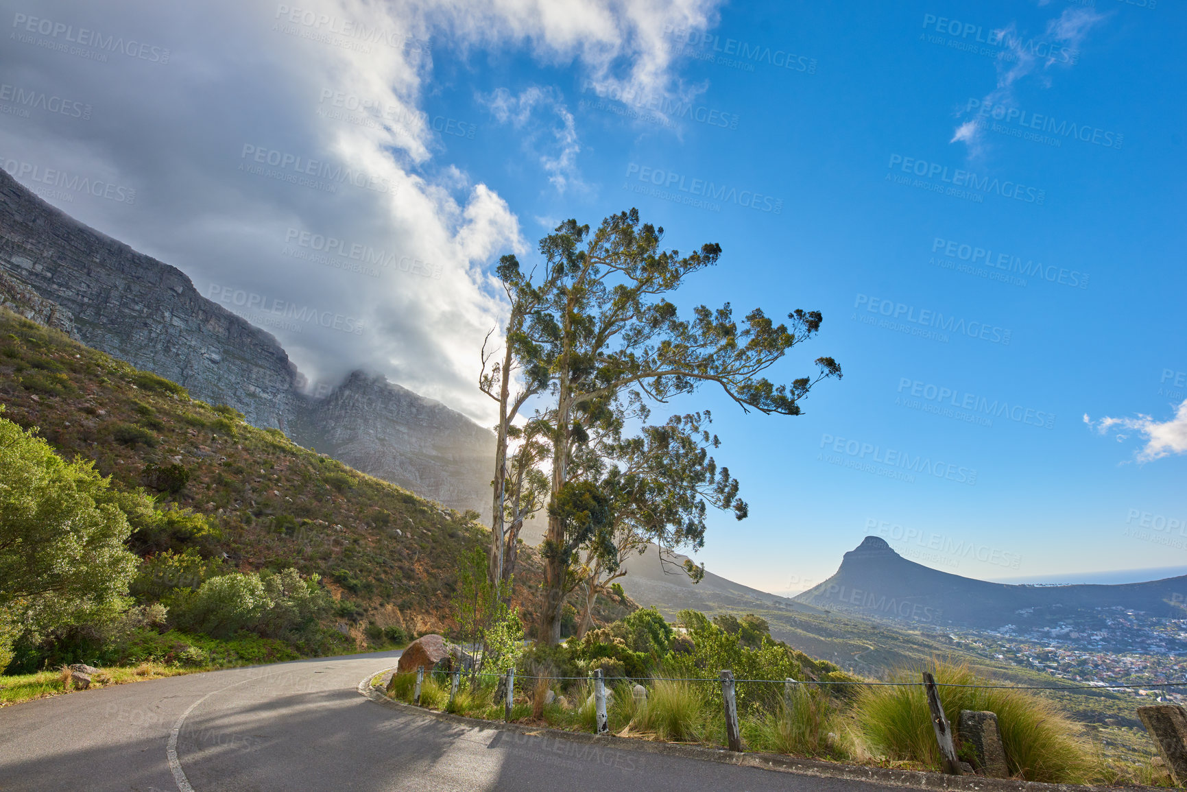 Buy stock photo Roadtrip through mountain view landscape on tar road or street with blue sky during summer in Cape Town, South Africa. Travel and leading to scenic, lush green hills for weekend exploring and driving
