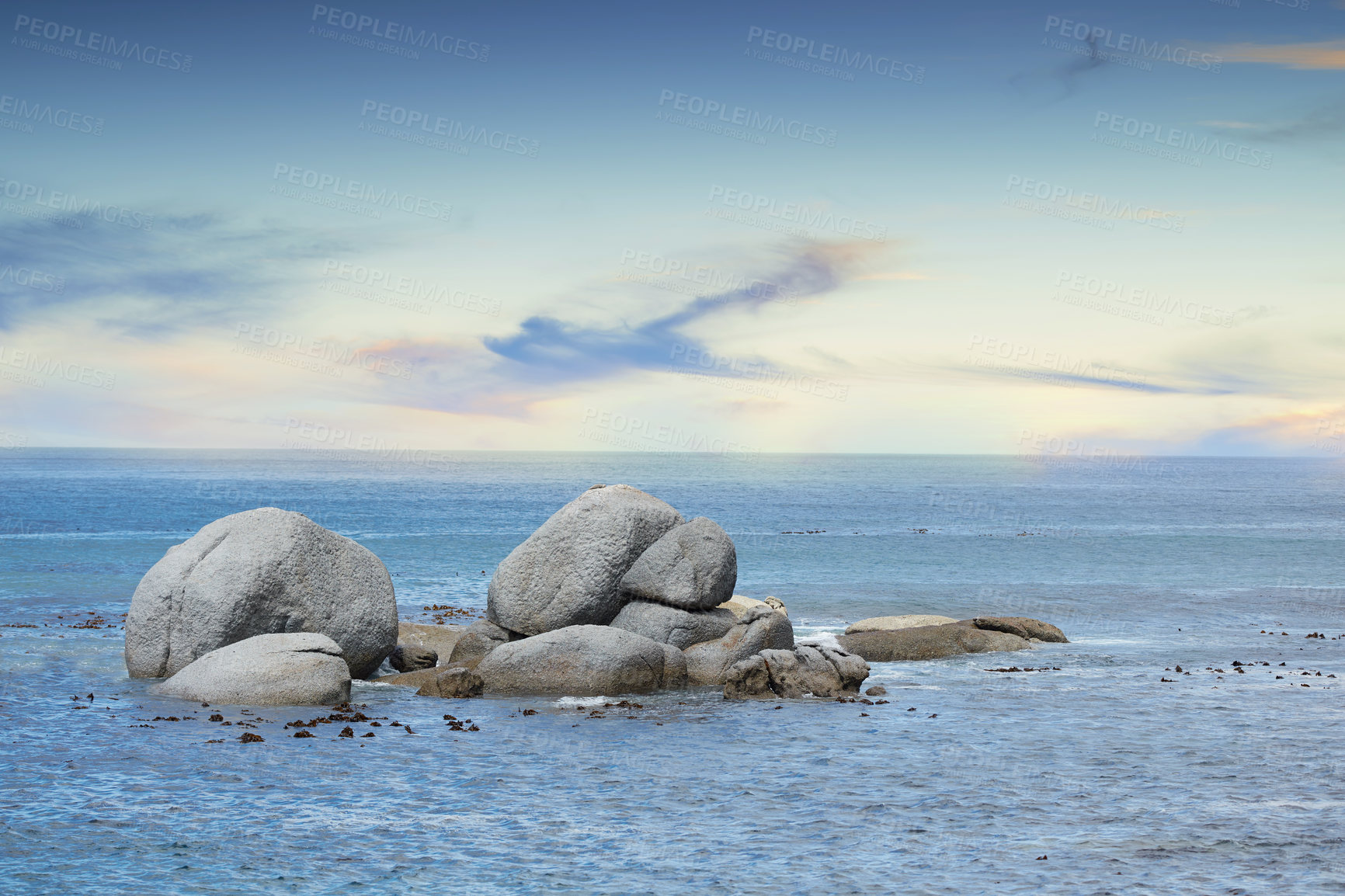 Buy stock photo Copyspace at sea with a cloudy blue sky background and rocky coast in Western Cape South Africa. View of calm scenic sea landscape with rocks. Stunning destination for a summer holiday background