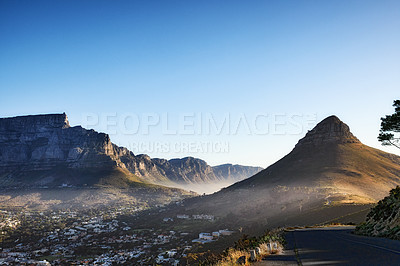 Buy stock photo Majestic mountain landscape under clear blue sky copy space on a breathtaking morning. Picturesque view of Table Mountain and Lions Head with a city in the valley. Landscape of a mountain range