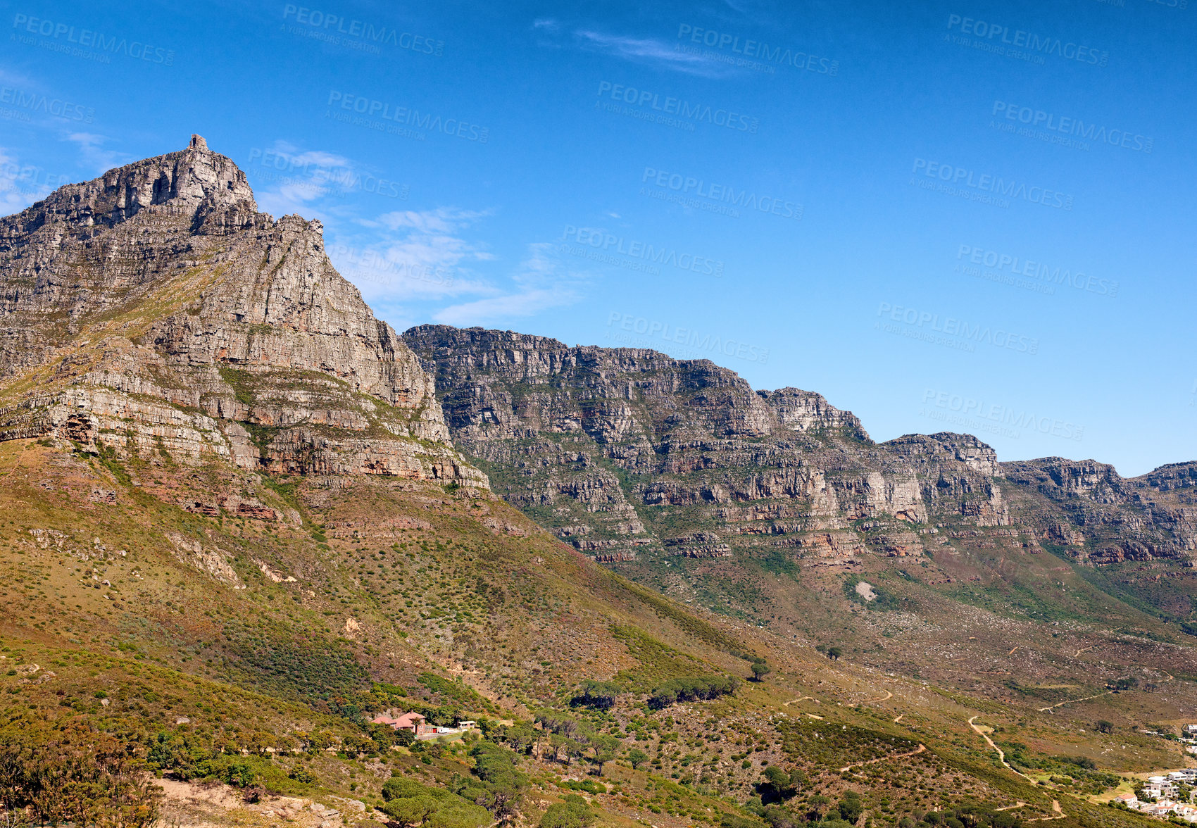 Buy stock photo Landscape of mountains on a blue sky background with copy space. Beautiful view of mountain outcrops with hills covered in green grass, trees and bushes on a popular landmark location in South Africa