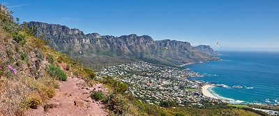 Buy stock photo Scenic hiking trail along Table Mountain with beautiful views of a coastal city against a blue sky background. Panoramic of a lush landscape by the sea around an iconic landmark to explore and travel
