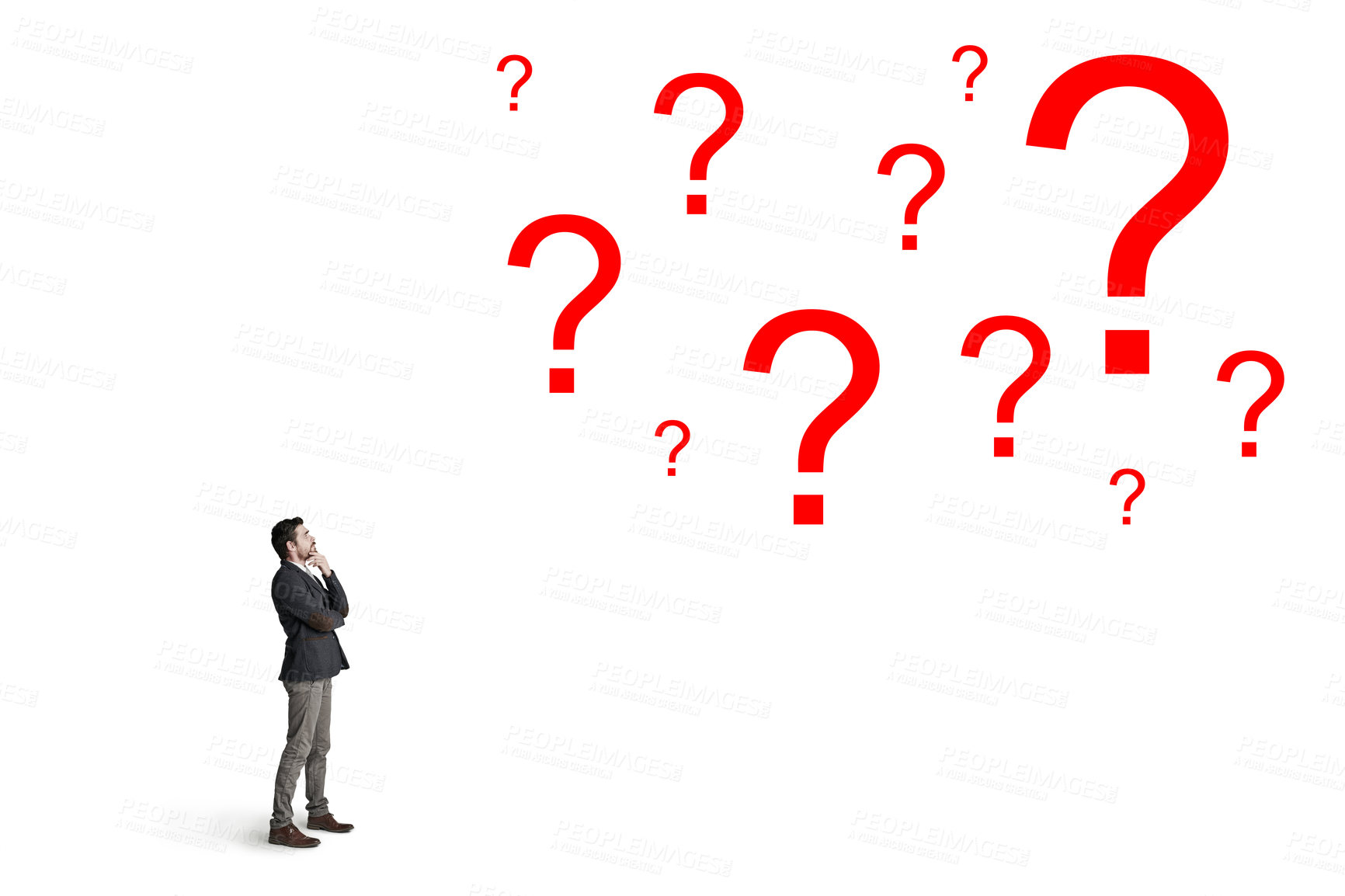 Buy stock photo Shot of a businessman looking up at question marks against a white background