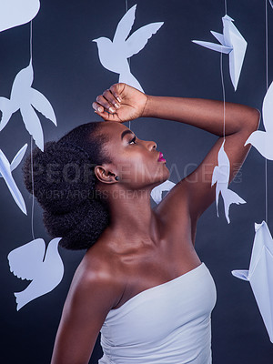 Buy stock photo Black woman, paper bird and beauty for freedom, peace and wellness isolated in dark background. African model, cosmetics and abstract fantasy with makeup, skincare and creative animal art or origami