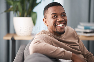 Buy stock photo Face, smile and portrait of a black man relax in a living room at a house on a holiday, break or weekend. Happiness, calm and young male sitting alone in a lounge in home or apartment relaxing
