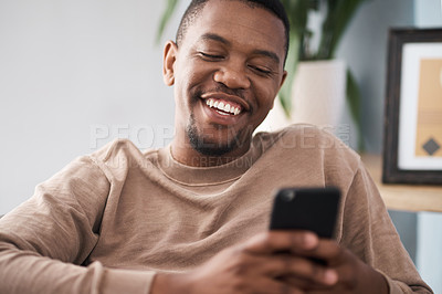 Buy stock photo Black man, phone and smile for social media, communication or texting while relaxing at home. Happy African American male smiling enjoying conversation, chatting or connectivity on mobile smartphone