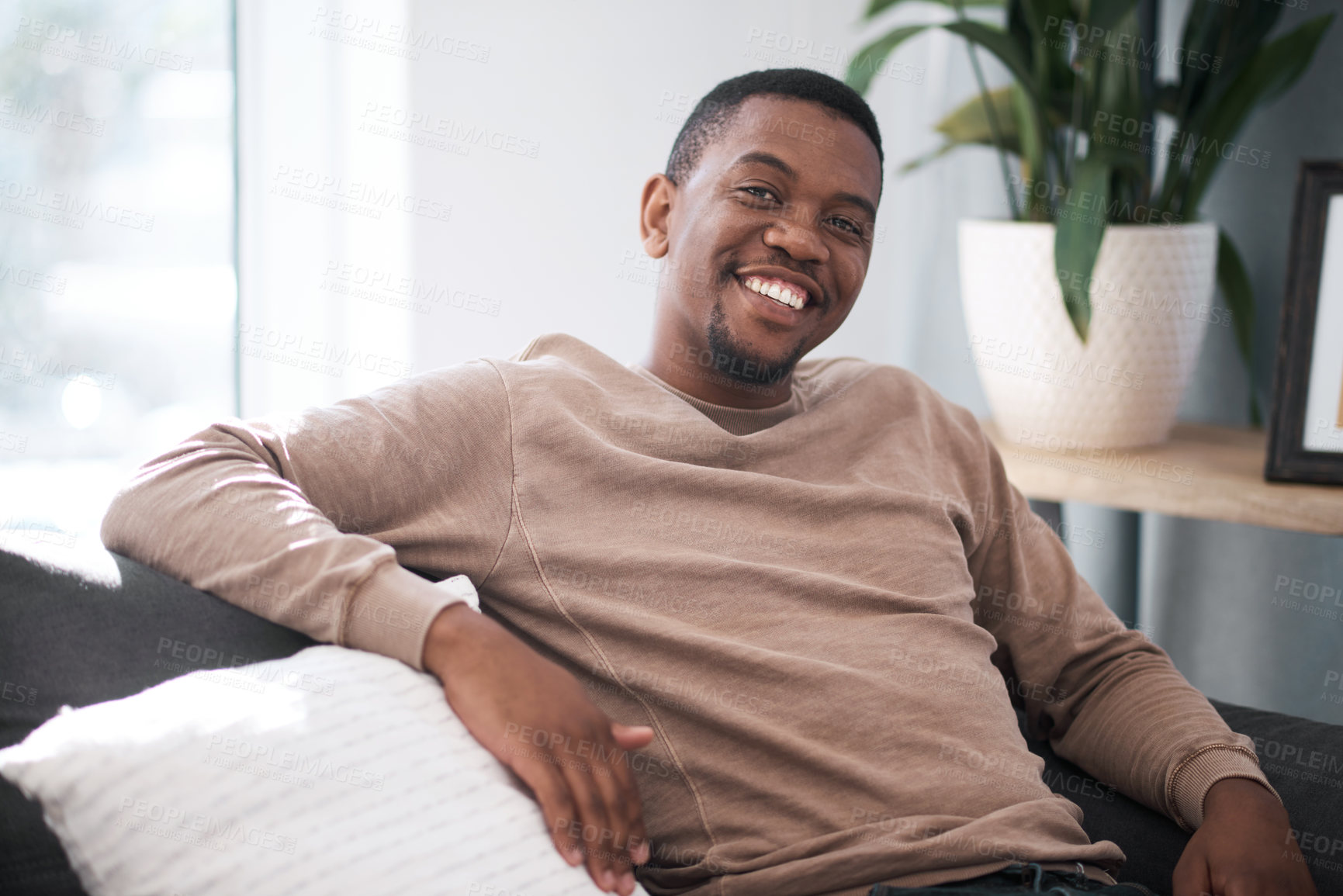 Buy stock photo Relax, smile and portrait of black man on sofa at home in city apartment. Happy, healthy and proud man and leader in business from South Africa smiling and relaxing alone on couch in living room.