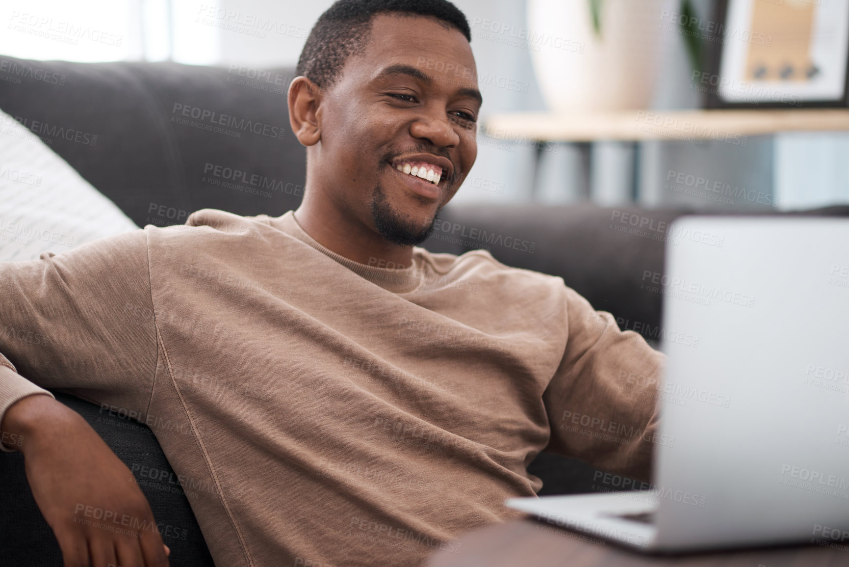 Buy stock photo Laptop, freelance and research with a black man doing remote work from the living room of a house.  Computer, startup and entrepreneur with a male employee reading an email while working from home