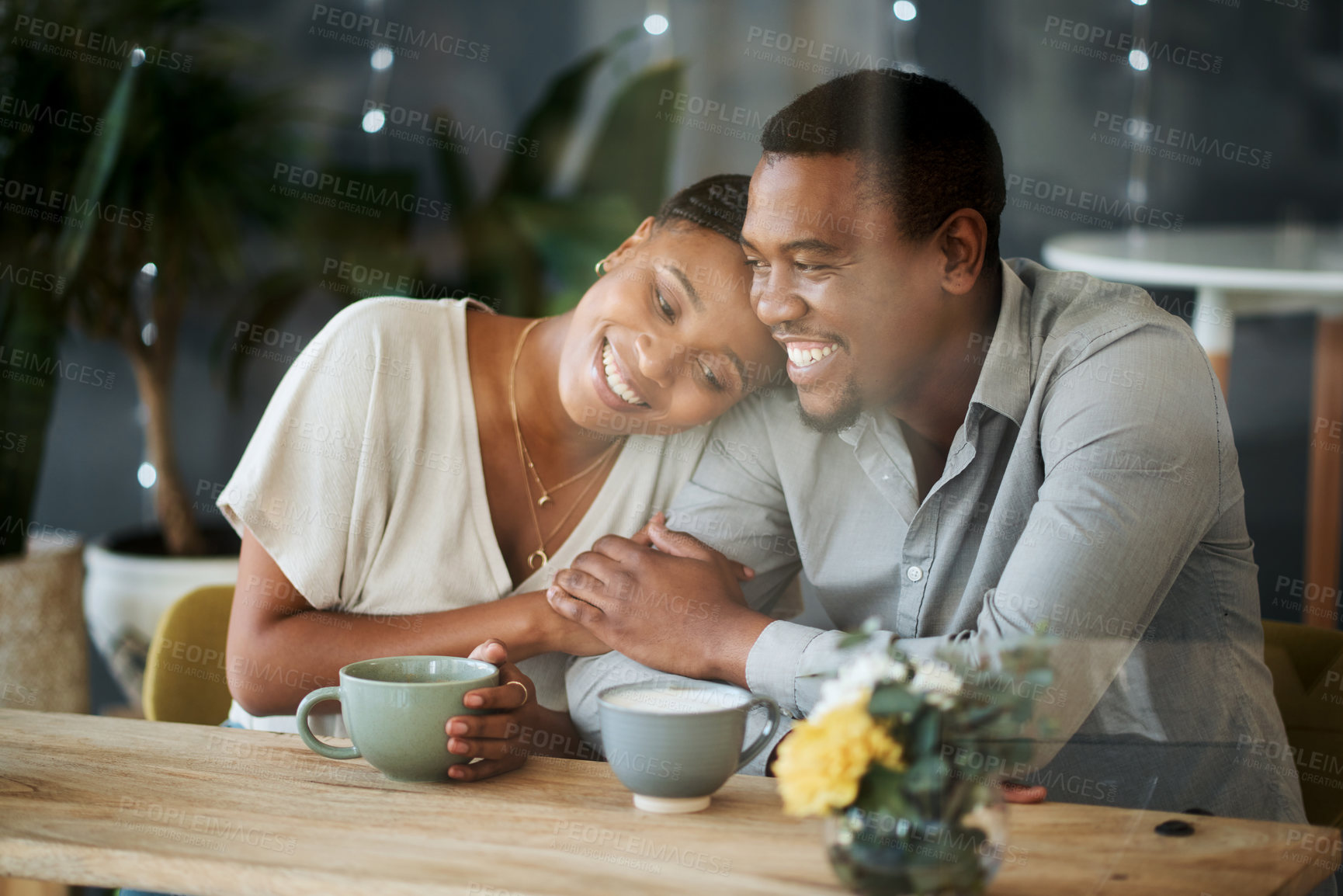 Buy stock photo Cafe, love and happy black couple on a date hugging, talking or holding hands while drinking coffee or tea. Happiness, relaxing and romantic black woman enjoys quality time with African partner 