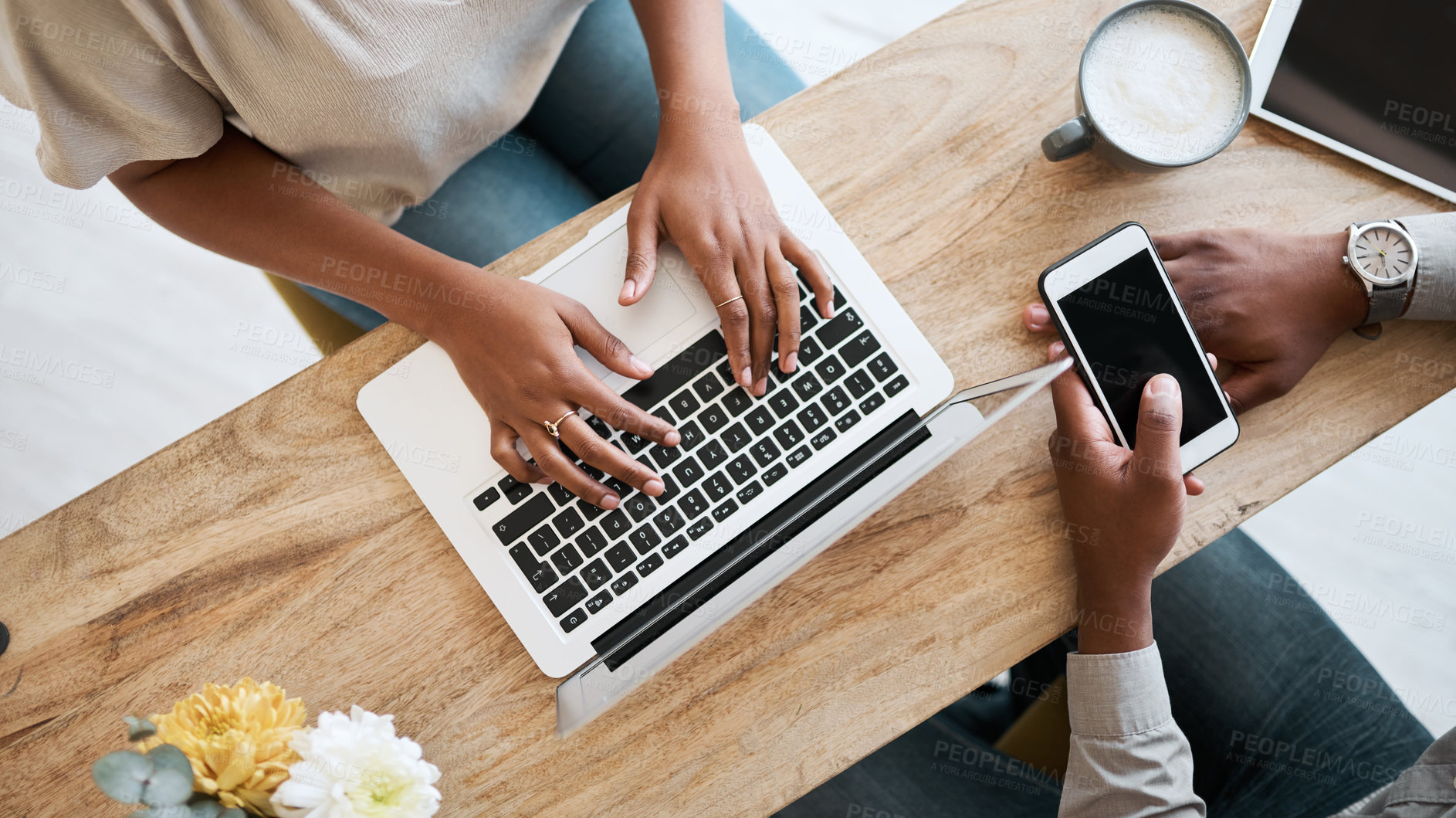 Buy stock photo Hands, laptop and phone with a coffee shop business team working together from above. Collaboration, technology and remote work with a black man and woman employee at wok in an internet cafe