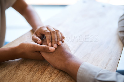 Buy stock photo Couple, holding hands and support on table in closeup for help, care and empathy in time of grief. Black couple, helping hand and love to forgive, consult or comfort together in home with kindness