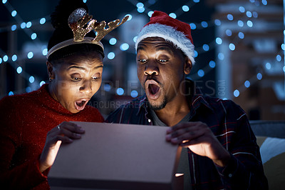 Buy stock photo Black couple, box and christmas gift open in surprise, wow and shock by magic light and looking excited. Night, couple and gift box fantasy, omg and amazed while sharing festive holiday in a home