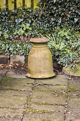 Buy stock photo A ceramic pot on a garden floor against green bushes. Details of an empty, weathered pot plant in a quiet, lonely yard. Old floral arrangement holder in an abandoned backyard. 