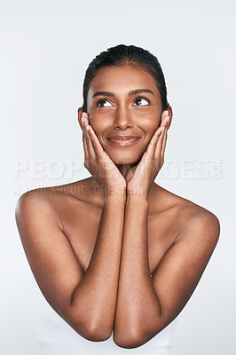 Buy stock photo Indian woman, beauty and skincare with thinking, ideas and smile for wellness, routine and facial treatment. Female person, happy and planning for cosmetics, dermatology and glow on studio background