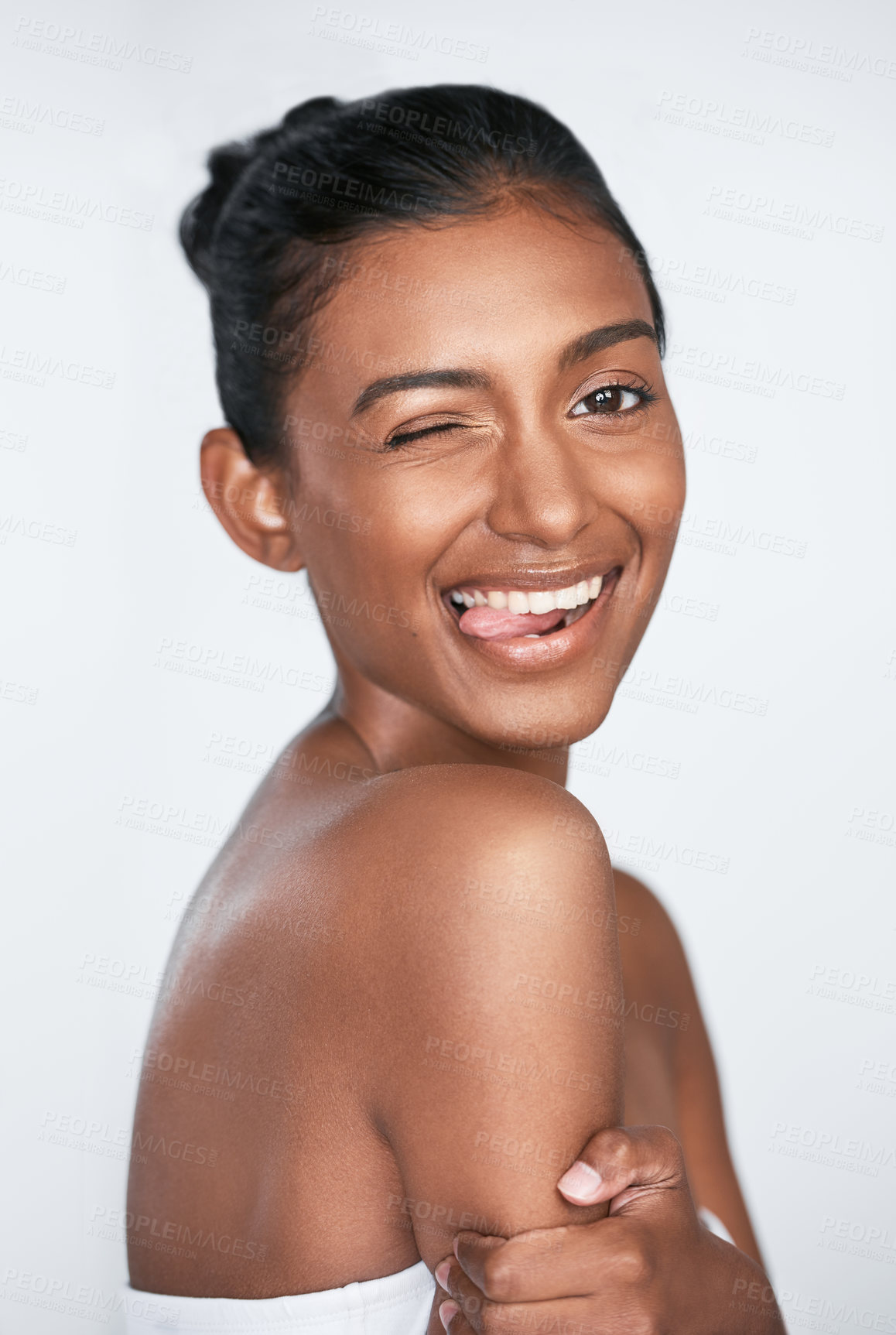 Buy stock photo Happy woman, portrait or natural beauty with hygiene or wink in skincare on a white studio background. Young, female person or indian model with tongue out for satisfaction, dermatology or anti aging