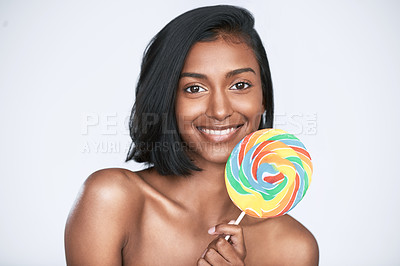 Buy stock photo Cropped shot of a beautiful woman holding a rainbow lollipop against a white background