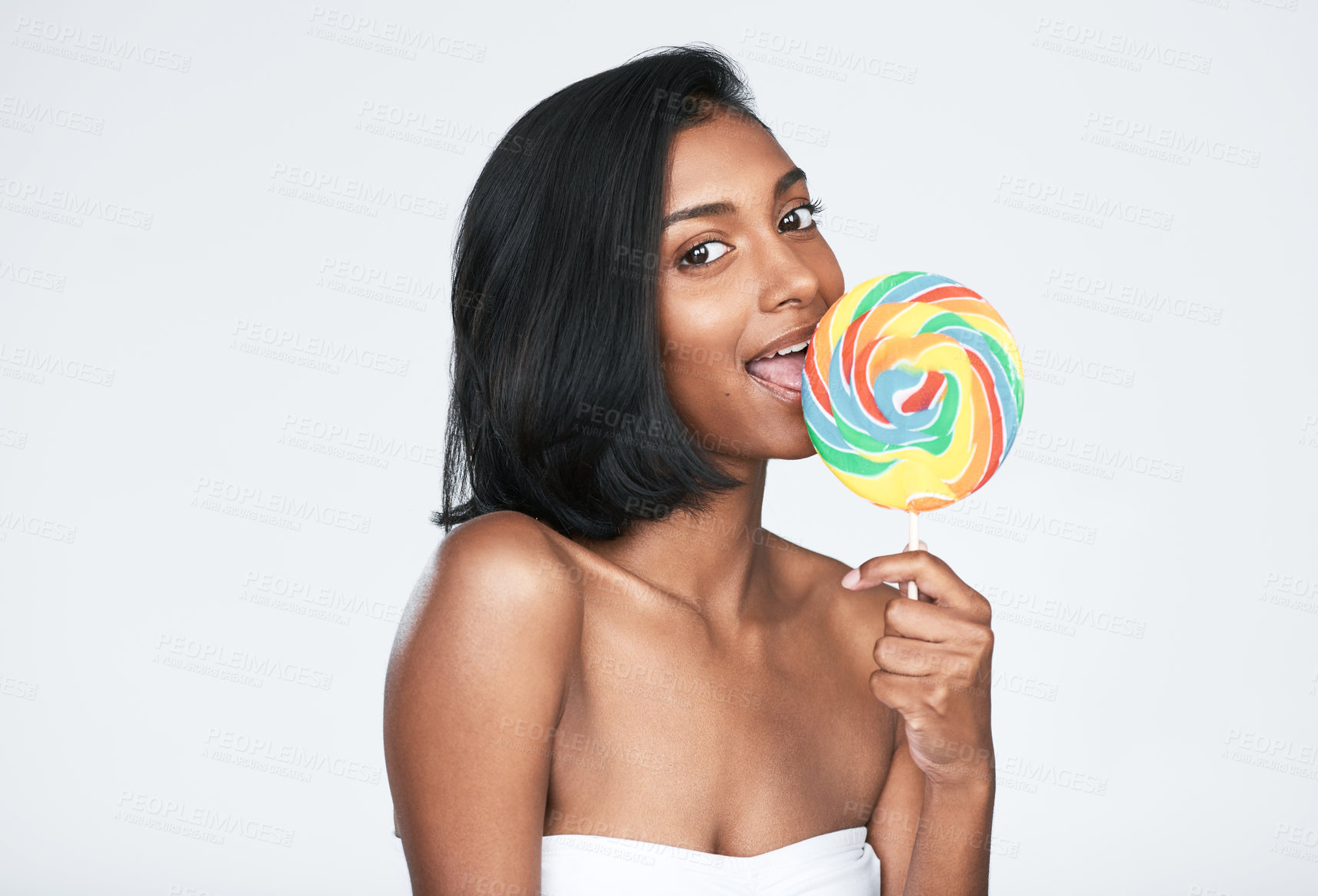 Buy stock photo Cropped shot of a beautiful woman holding a rainbow lollipop against a white background
