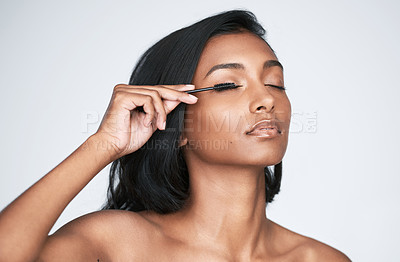 Buy stock photo Cropped shot of a beautiful young woman applying mascara