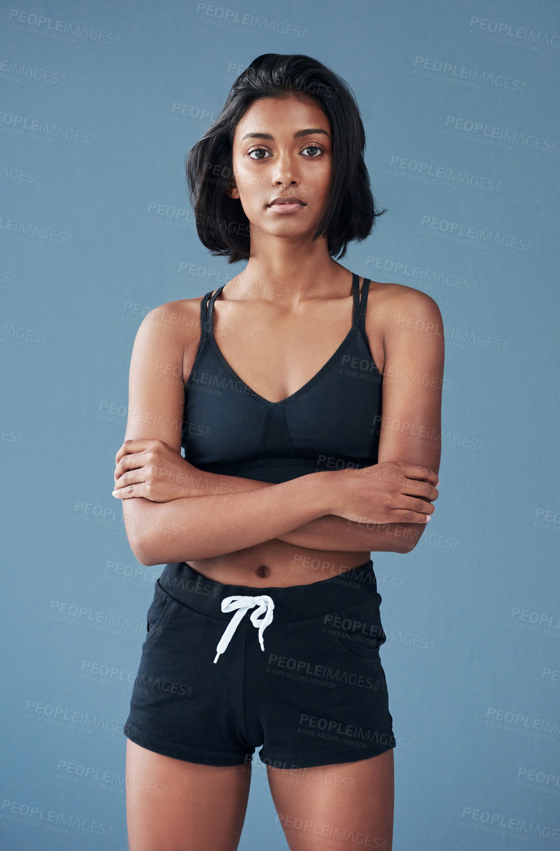 Buy stock photo Shot of a sporty young woman posing against a blue background