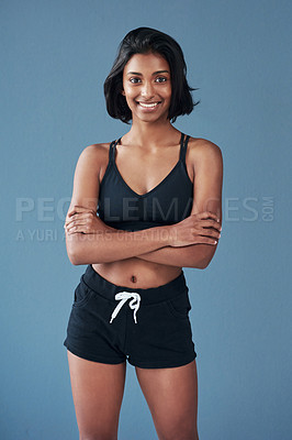 Buy stock photo Shot of a sporty young woman posing against a blue background