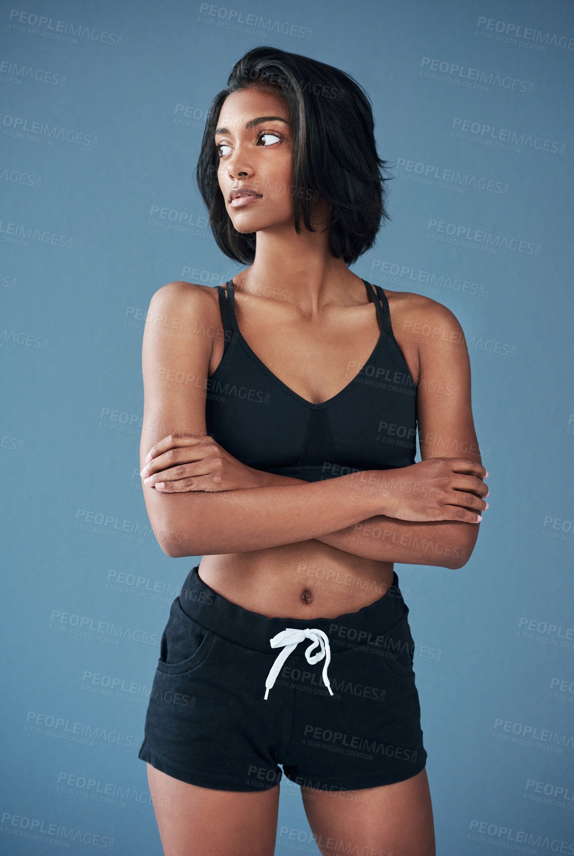 Buy stock photo Shot of a sporty young woman posing against a blue background