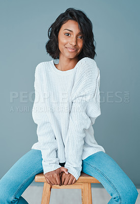 Buy stock photo Shot of a beautiful young woman sitting on a chair against a teal background