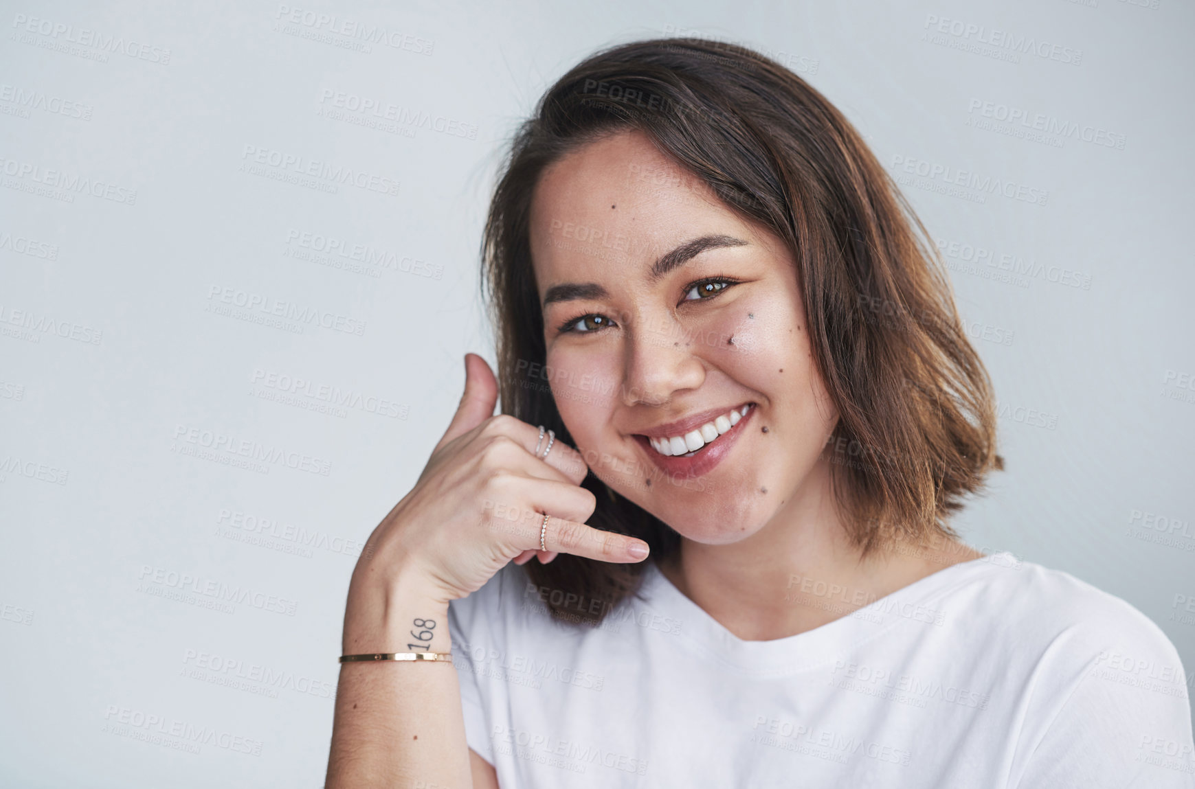 Buy stock photo Portrait, phone call and woman with smile, sign and promotion on white studio background. Face, person and girl with hand gesture, icon for communication and suggestion with option, joy and feedback