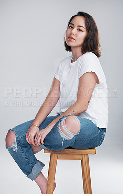 Buy stock photo Cropped shot of a beautiful young woman sitting against a white background