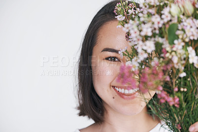Buy stock photo Shot of a beautiful young woman posing with a bouquet against a white background