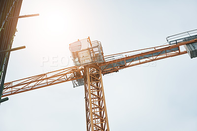 Buy stock photo Shot of a crane at a construction site