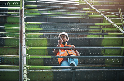 Buy stock photo Shot of a young woman using a walkie talkie while working at a construction site