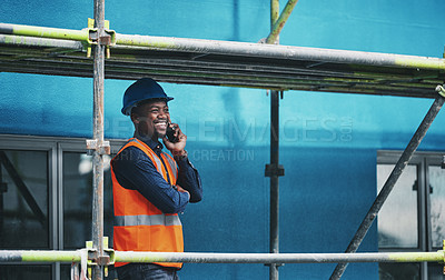 Buy stock photo Shot of a young man talking on a cellphone while working at a construction site